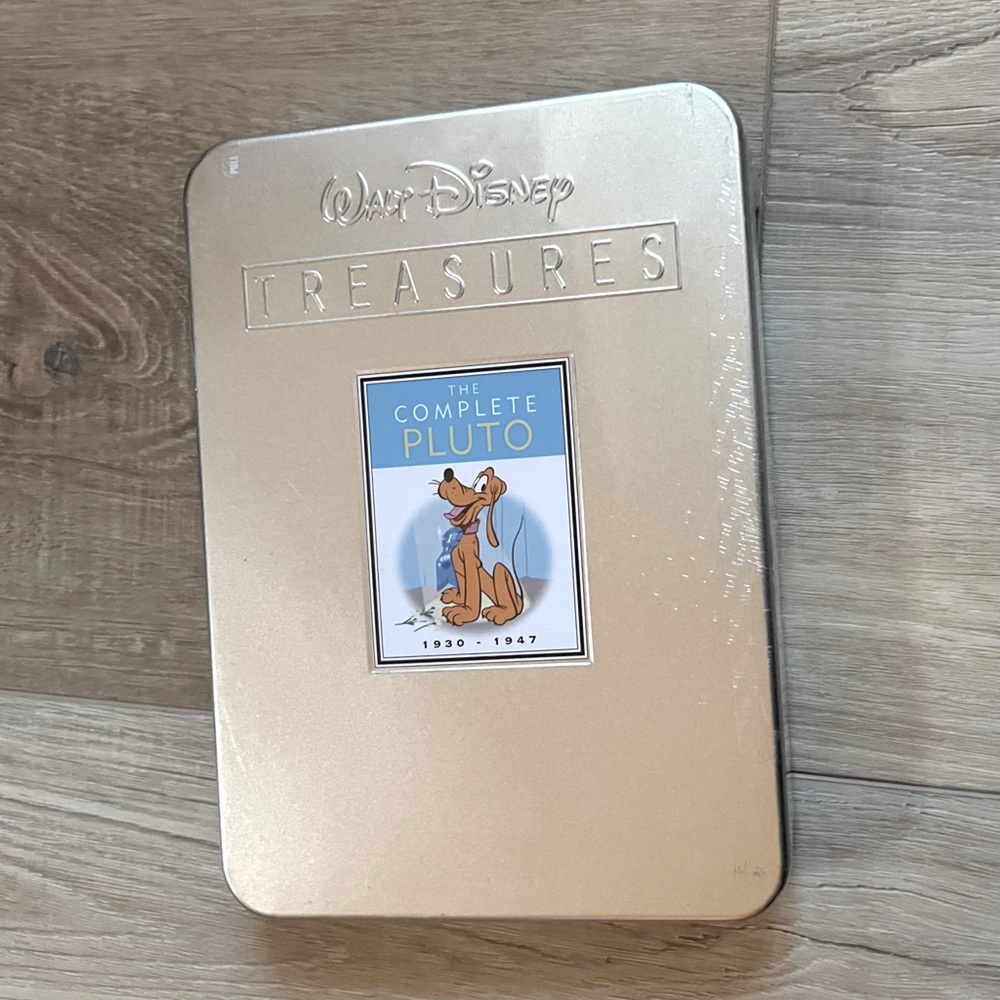 New. Still sealed Pluto collectors dvd in collectors tin.